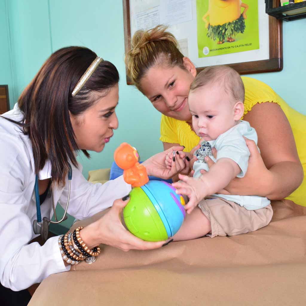Doctor saludando cordialmente a un niño en la consulta médica